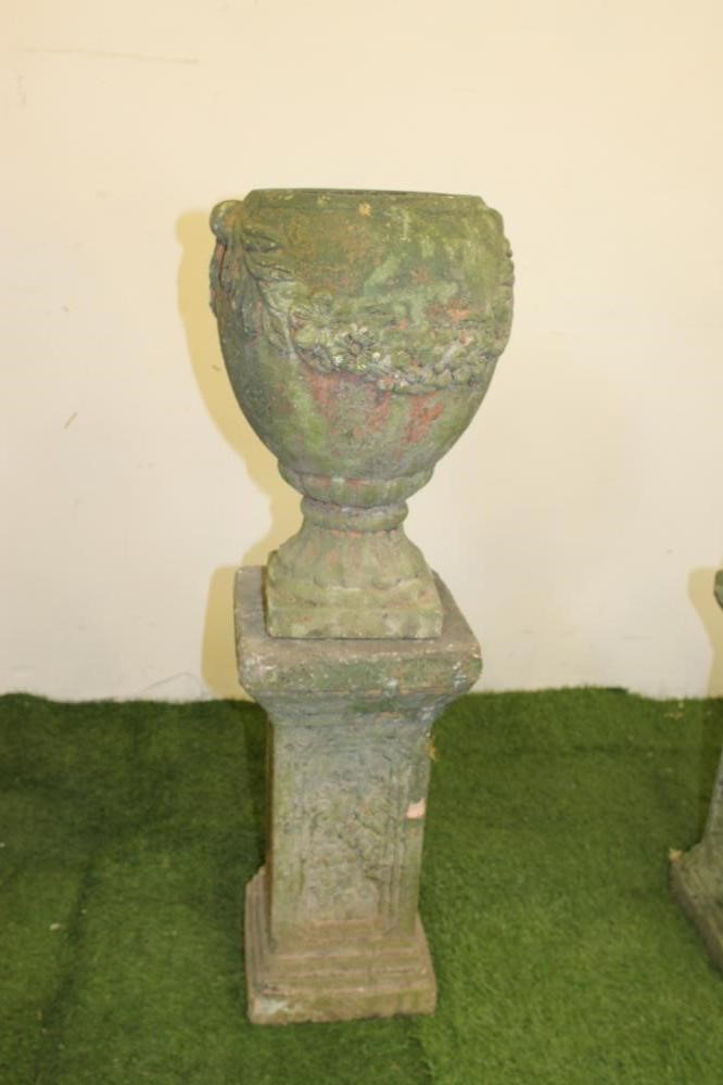 A PAIR OF TERRACOTTA URNS of ovoid form with floral festoons in relief Image