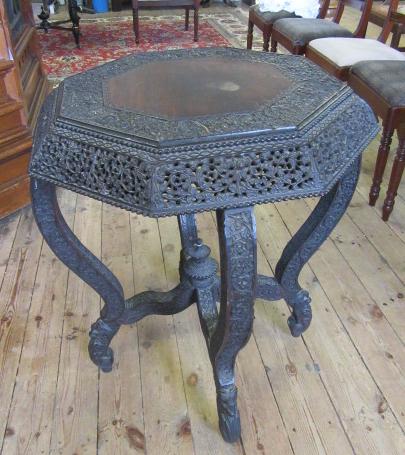 A BURMESE CARVED HARDWOOD CENTRE TABLE of octagonal form with pierced frieze Image