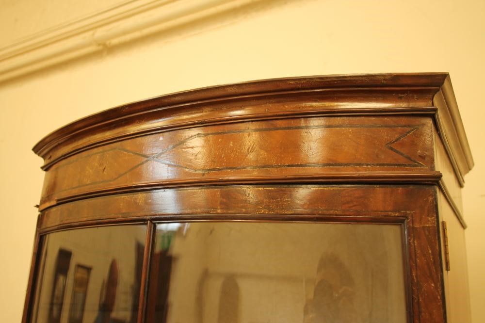 AN EDWARDIAN MAHOGANY DISPLAY CABINET of bowed form with ebony stringing Image