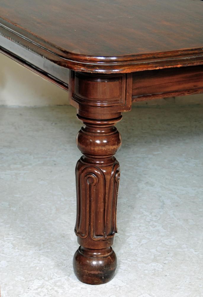 A VICTORIAN MAHOGANY EXTENDING DINING TABLE with three leaves housed in a separate case Image