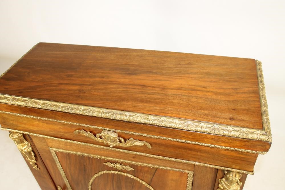 A VICTORIAN WALNUT PIER CABINET of shallow oblong form with gilt metal mounts Image