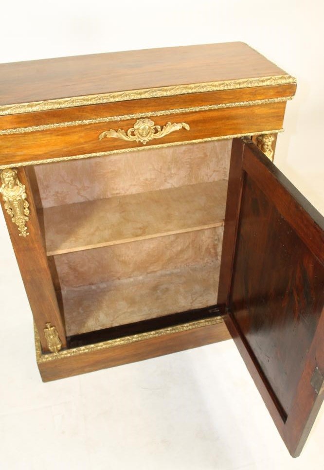 A VICTORIAN WALNUT PIER CABINET of shallow oblong form with gilt metal mounts Image