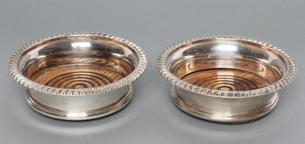 A PAIR OF SILVER BOTTLE COASTERS Image