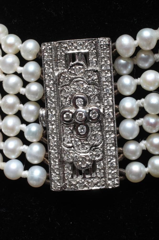 A SEVEN STRAND CULTURED PEARL CHOKER with two diamond set spacing bars to a white oblong clasp Image