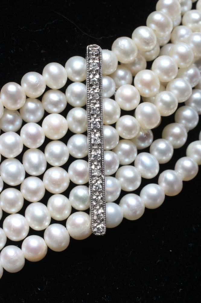 A SEVEN STRAND CULTURED PEARL CHOKER with two diamond set spacing bars to a white oblong clasp Image