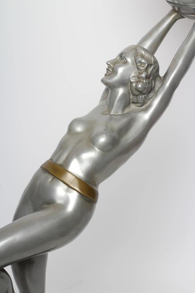 AFTER LORENZL - a large silvered metal figural lamp base modelled as a young female nude standing on Image