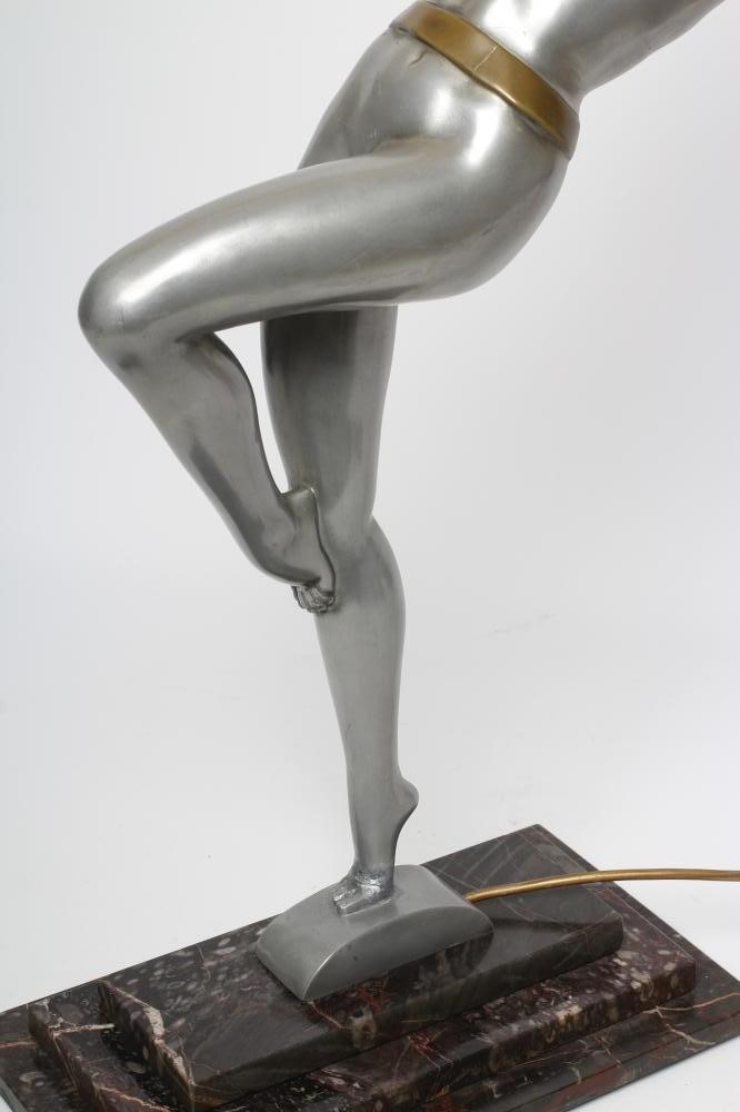 AFTER LORENZL - a large silvered metal figural lamp base modelled as a young female nude standing on Image