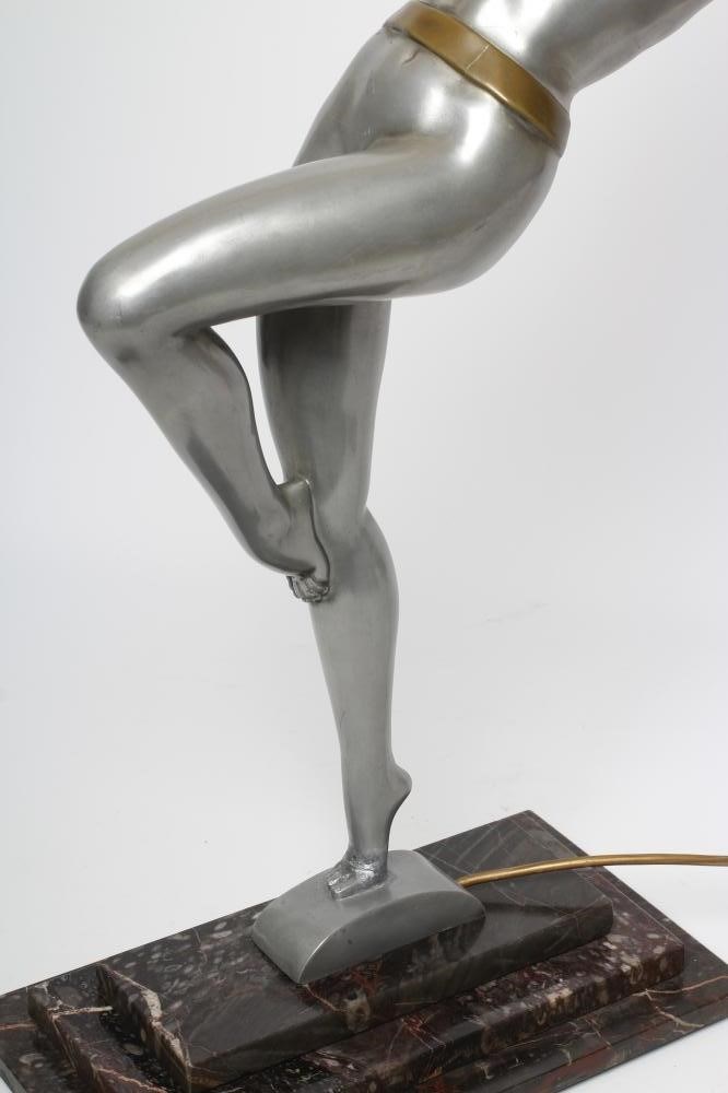 AFTER LORENZL - a large silvered metal figural lamp base modelled as a young female nude standing on Image