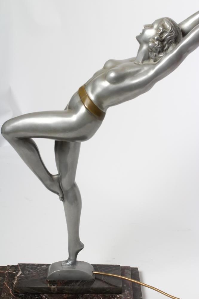 AFTER LORENZL - a large silvered metal figural lamp base modelled as a young female nude standing on Image