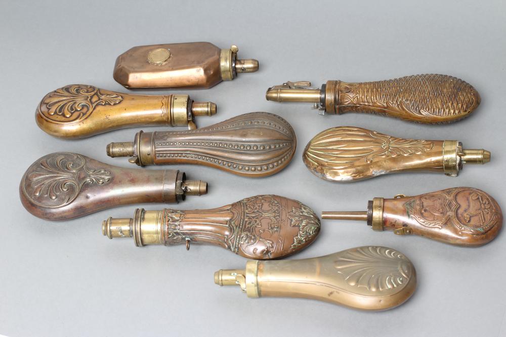 A COLLECTION OF POWDER FLASKS all with embossed designs Image