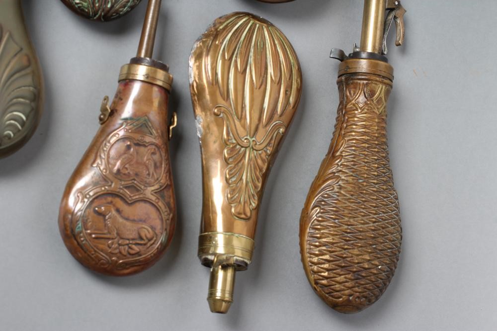 A COLLECTION OF POWDER FLASKS all with embossed designs Image