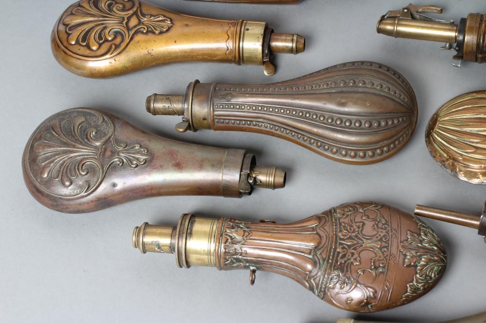 A COLLECTION OF POWDER FLASKS all with embossed designs Image