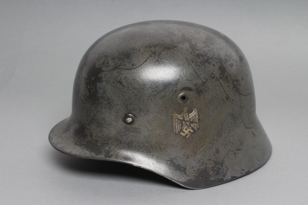 A THIRD REICH M35 ARMY HELMET painted in green with applied shield and reichsadler Image