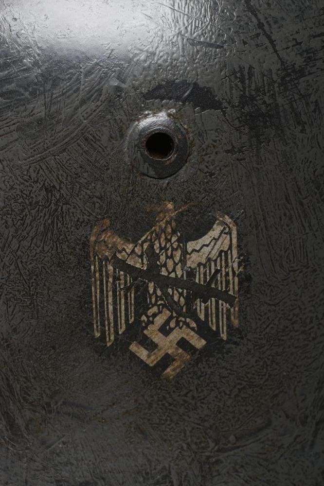 A THIRD REICH M35 ARMY HELMET painted in green with applied shield and reichsadler Image