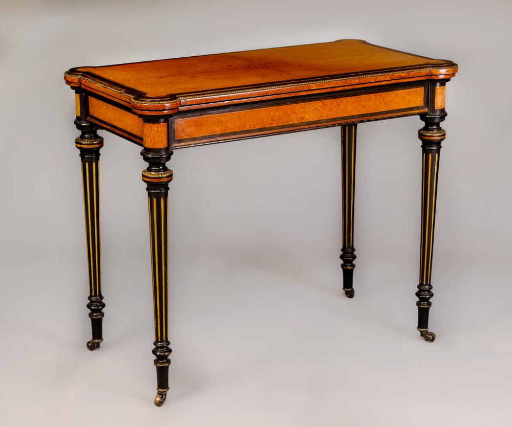 A VICTORIAN AMBOYNA AND EBONISED FOLDING CARD TABLE of earred oblong form with gilt metal mounts Image
