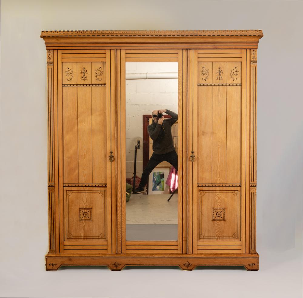 A VICTORIAN AESTHETIC ASH TRIPLE WARDROBE with black painted foliate scrolls and geometric banding Image