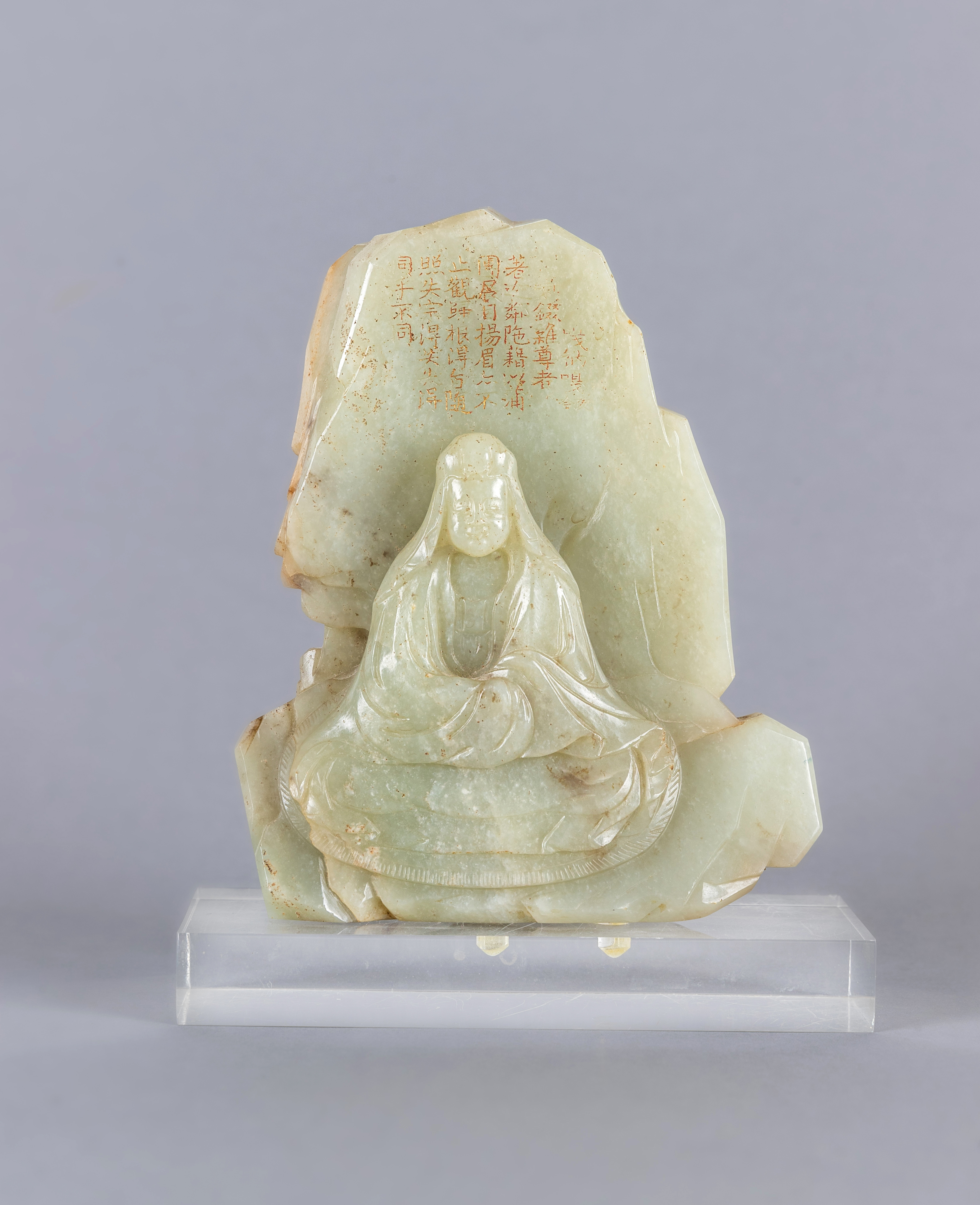 A CHINESE JADE DEITY seated before rockwork with engraved and stained red and gilt script Image