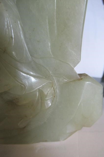 A CHINESE JADE DEITY seated before rockwork with engraved and stained red and gilt script Image
