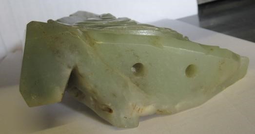 A CHINESE JADE DEITY seated before rockwork with engraved and stained red and gilt script Image