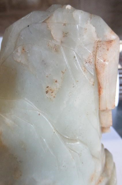 A CHINESE JADE DEITY seated before rockwork with engraved and stained red and gilt script Image