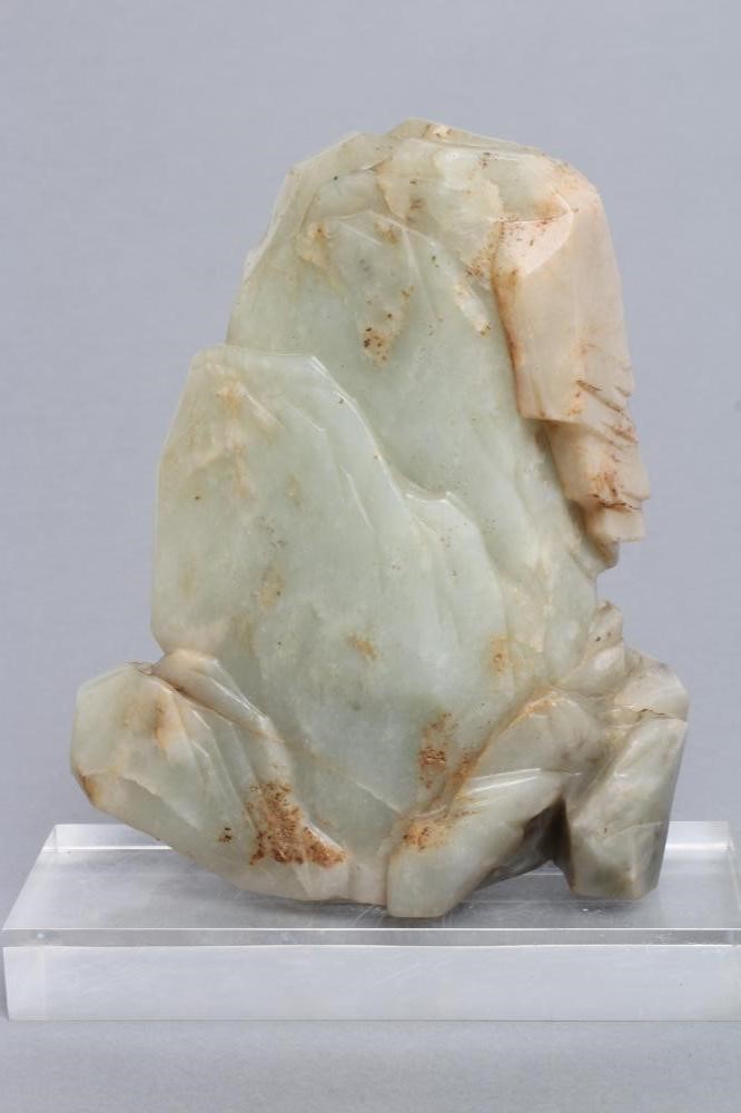 A CHINESE JADE DEITY seated before rockwork with engraved and stained red and gilt script Image