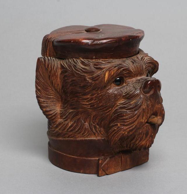 A "BLACK FOREST" CARVED WOOD TOBACCO JAR modelled as a smoking dog's head with glass eyes and hinged Image