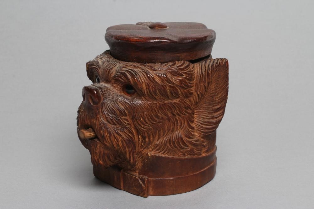 A "BLACK FOREST" CARVED WOOD TOBACCO JAR modelled as a smoking dog's head with glass eyes and hinged Image