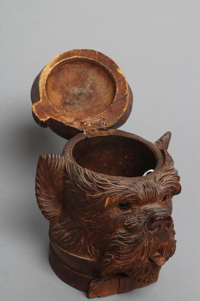 A "BLACK FOREST" CARVED WOOD TOBACCO JAR modelled as a smoking dog's head with glass eyes and hinged Image