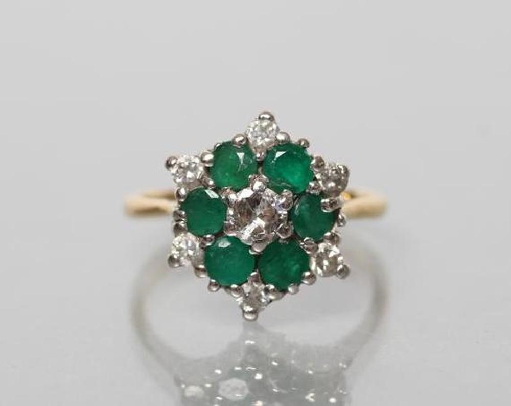 A DIAMOND AND EMERALD CLUSTER RING Image