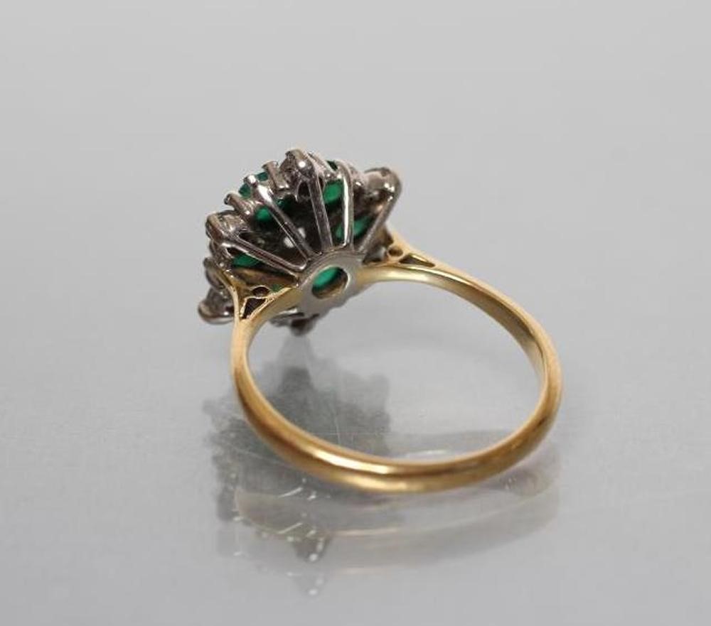 A DIAMOND AND EMERALD CLUSTER RING Image