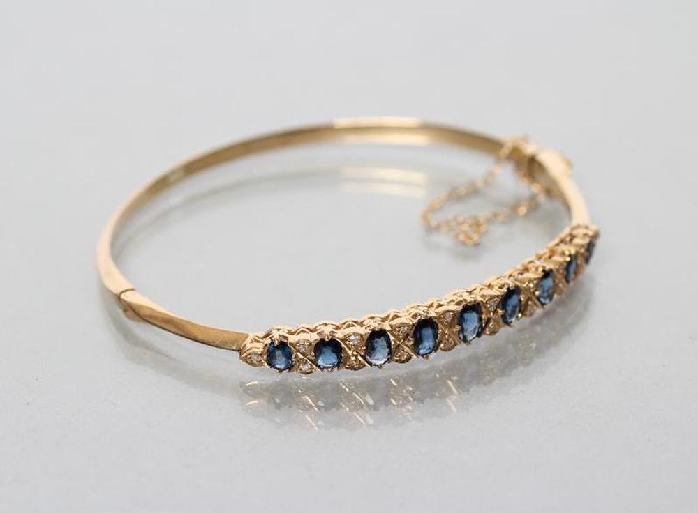 A SAPPHIRE AND DIAMOND STIFF HINGED BANGLE Image
