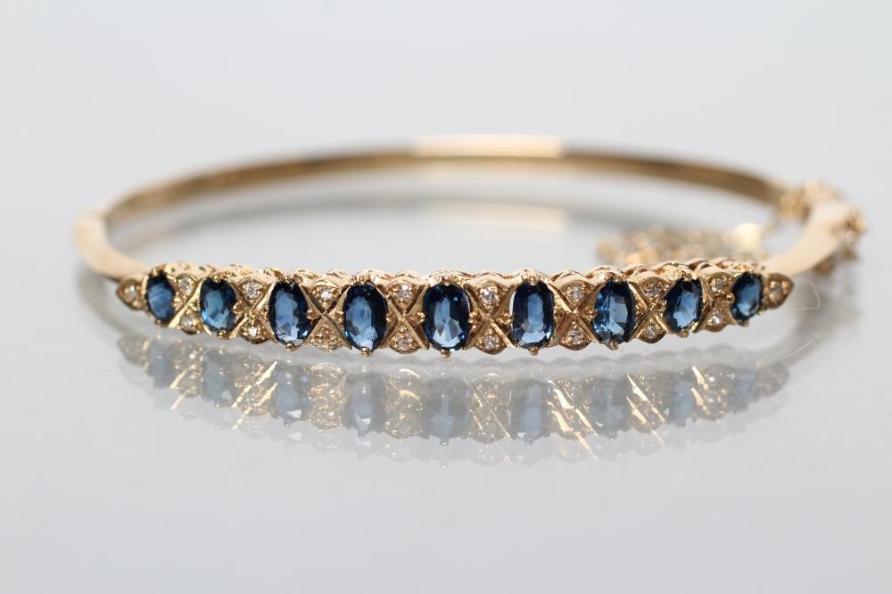 A SAPPHIRE AND DIAMOND STIFF HINGED BANGLE Image