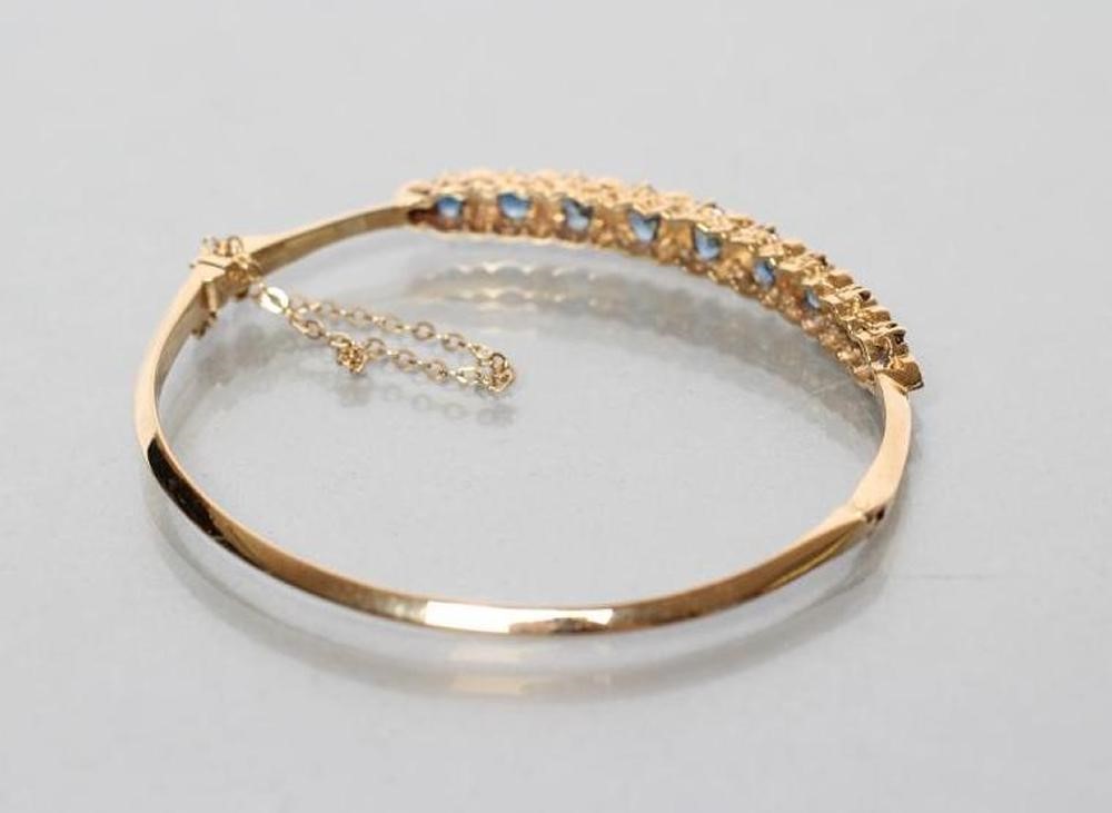A SAPPHIRE AND DIAMOND STIFF HINGED BANGLE Image