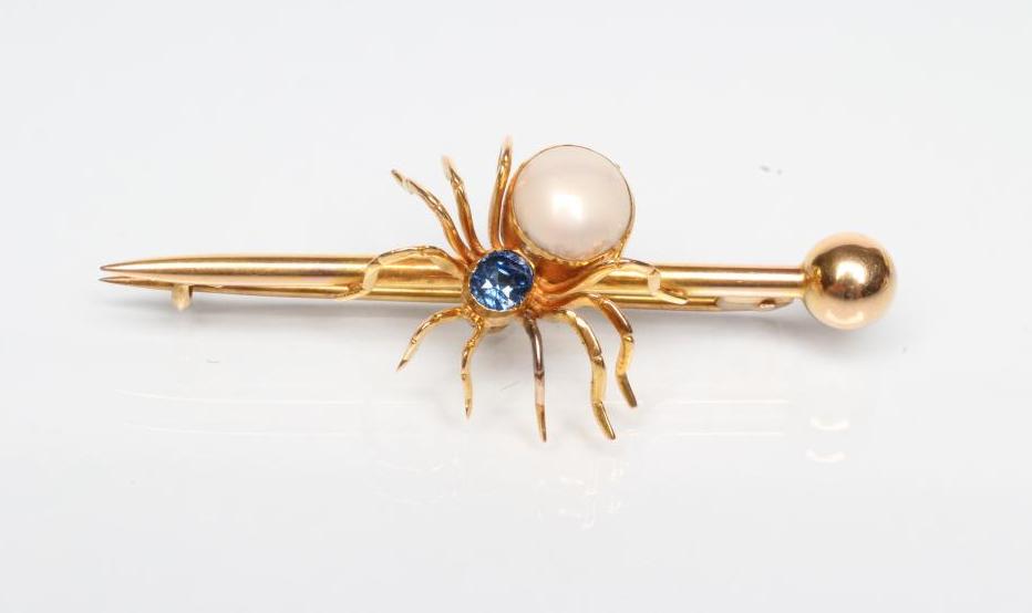 AN EDWARDIAN SPIDER BROOCH with oval facet cut sapphire head and blister pearl body on arrow head Image