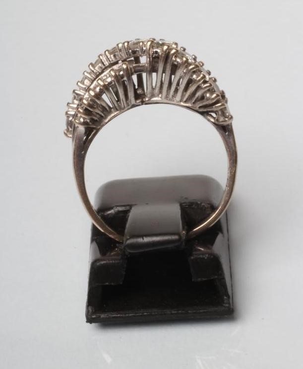 A DIAMOND RING crossover set with eleven graduated brilliant cut stones over fourteen small Image