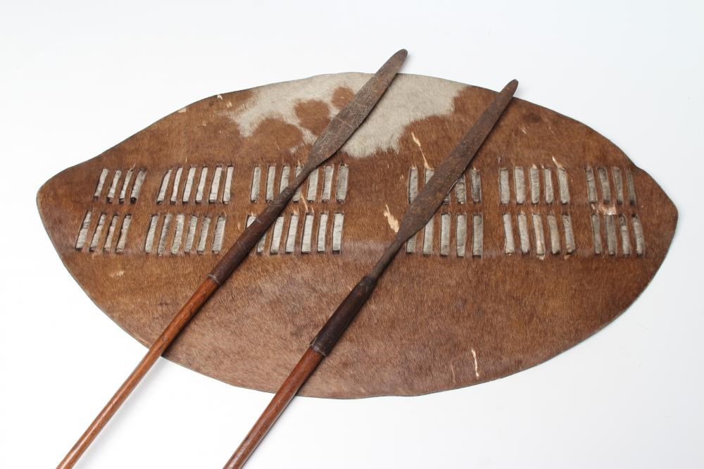 A ZULU COWHIDE SHIELD AND TWO ASSAGAI Image