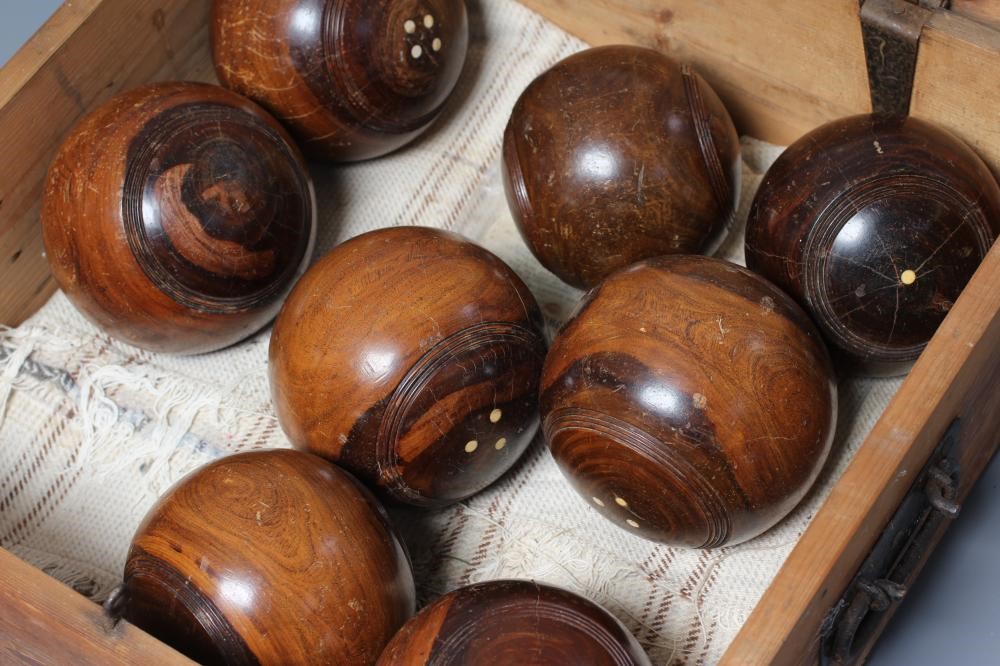 A SET OF EIGHT LIGNUM VITAE LAWN BOWLING BALLS together with a pair of Jacks Image
