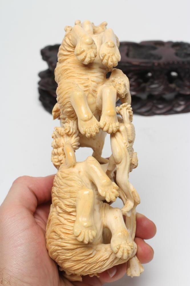 A CHINESE IVORY MODEL carved as a pair of Temple Dogs and their two puppies playing with a puzzle Image