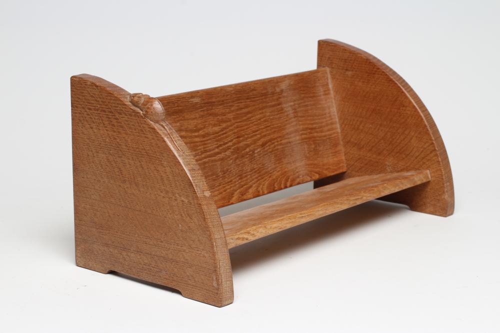 A ROBERT THOMPSON ADZED OAK BOOK TROUGH of quadrant form with carved mouse trademark in high relief Image