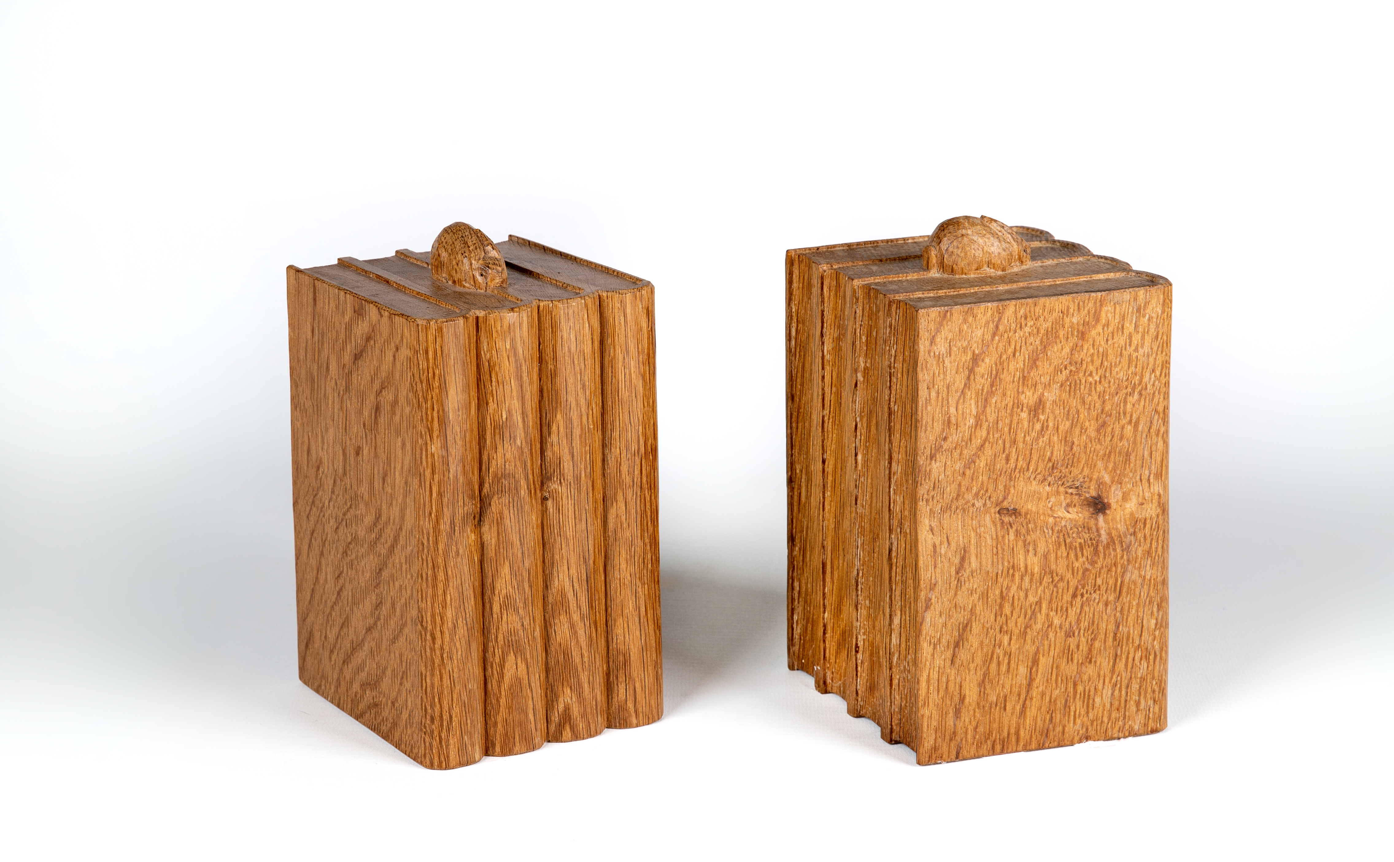 A PAIR OF PETER HEAP ADZED OAK BOOKENDS each carved as four books surmounted by a rabbit trademark Image