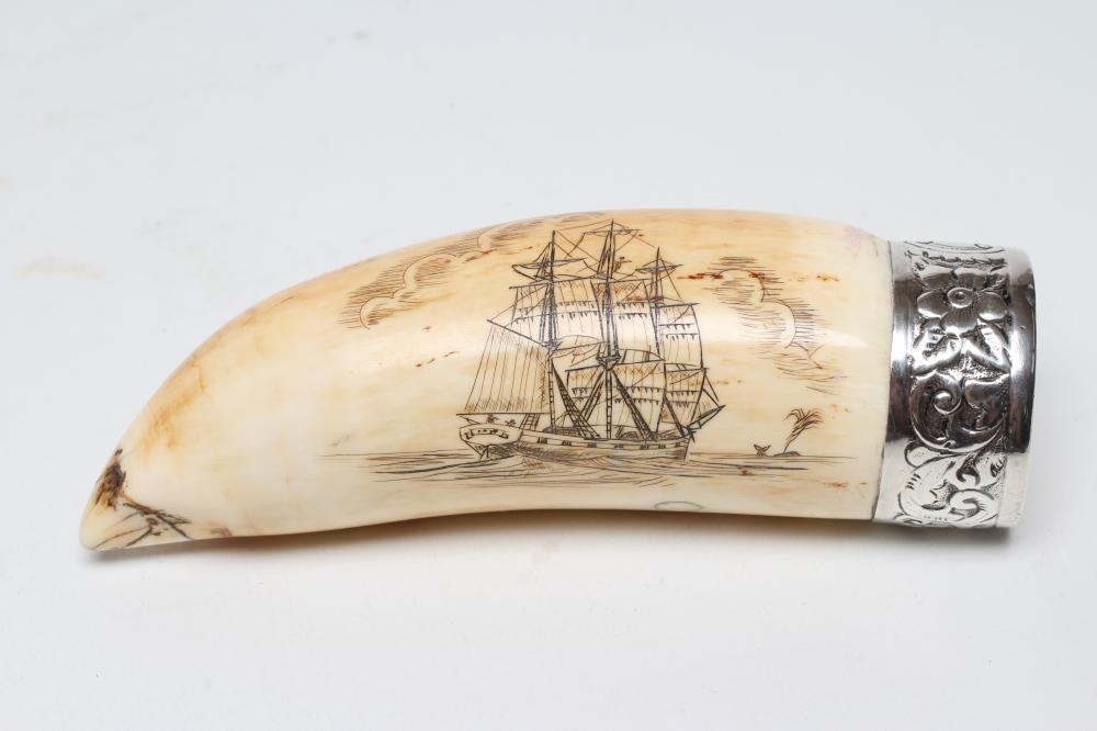A SCRIMSHAW engraved  with a three masted sailing ship off a palm island below clouds on a stained Image