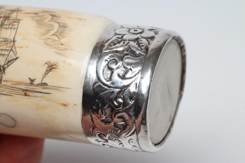 A SCRIMSHAW engraved  with a three masted sailing ship off a palm island below clouds on a stained Image