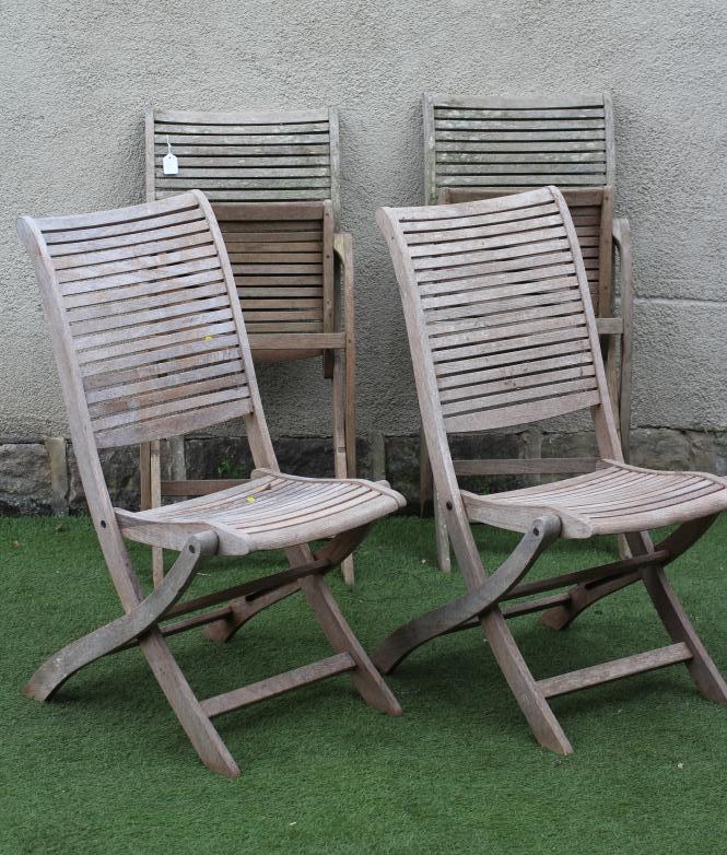 A SET OF FOUR TEAK FOLDING GARDEN CHAIRS with slatted seat and back on shaped square section Image