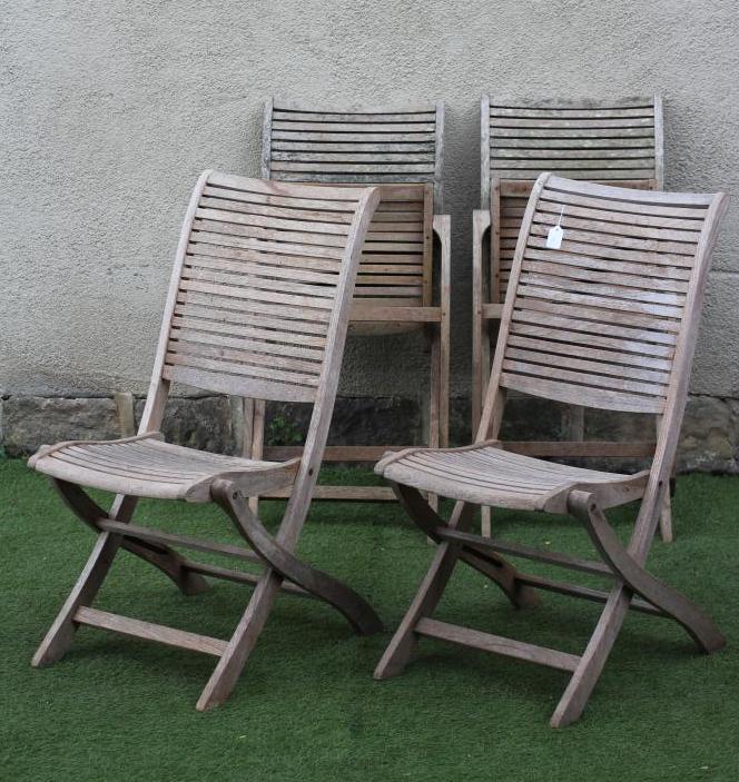 A SET OF FOUR TEAK FOLDING GARDEN CHAIRS with slatted seat and back on shaped square section Image