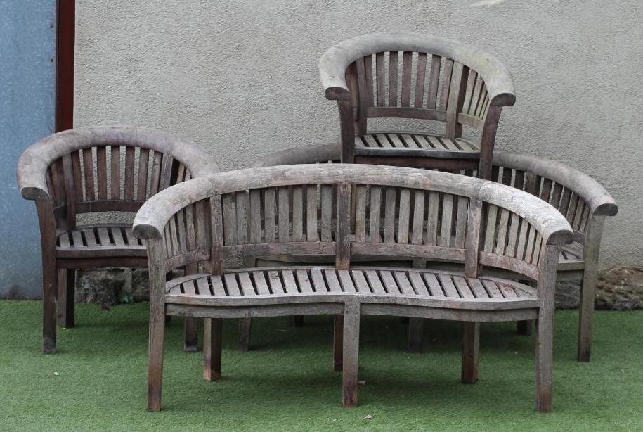 A BRAMBLE CREST TEAK SITTING SUITE comprising a pair of slatted sofas of curved back and serpentine Image
