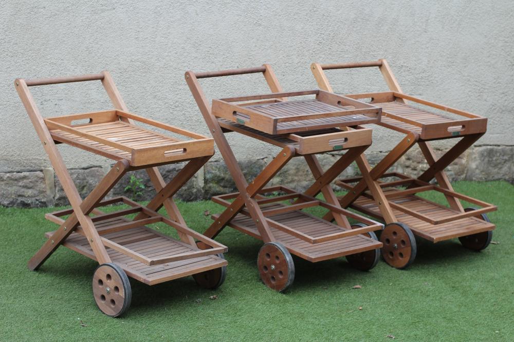 A SET OF THREE TEAK DRINKS TROLLEYS with removable slatted top tray Image