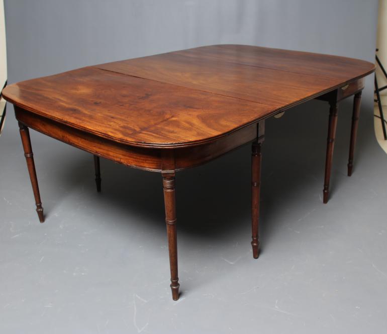 A GEORGIAN MAHOGANY EXTENDING DINING TABLE Image
