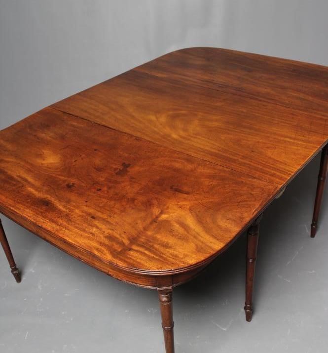 A GEORGIAN MAHOGANY EXTENDING DINING TABLE Image