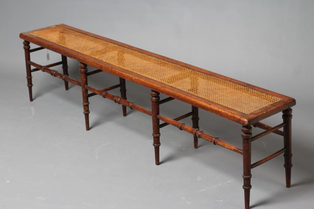 A VICTORIAN WALNUT(?) BENCH of rounded oblong form with caned seat Image