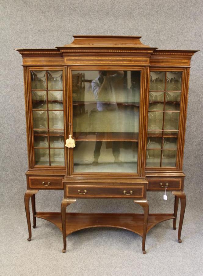 AN EDWARDIAN MAHOGANY DISPLAY CABINET of breakfront form crossbanded with stringing Image